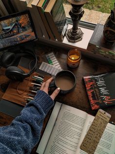 a person sitting at a table with an open book and coffee cup in front of them