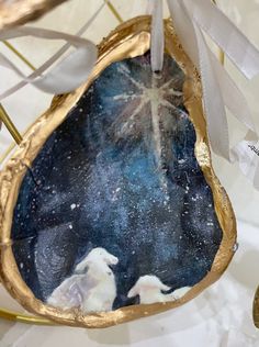 an ornament with two white birds and a star in the sky on it