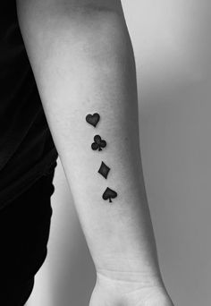 a woman's arm with four playing cards on it