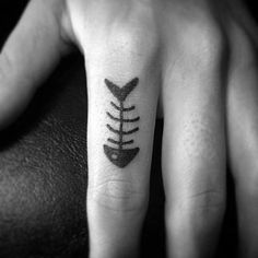 a person's hand with a tattoo on it and a fishbone in the middle