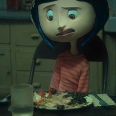 a doll sitting at a table with food on it