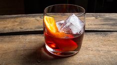 a glass filled with ice and fruit on top of a wooden table