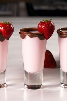 three shot glasses filled with chocolate and strawberries