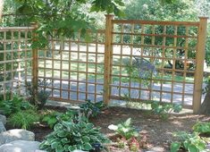 a wooden fence surrounded by rocks and plants