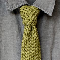 a man wearing a green crocheted tie with grey shirt and gray button down shirt