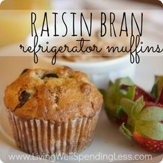 a muffin sitting on top of a white plate next to a bowl of fruit