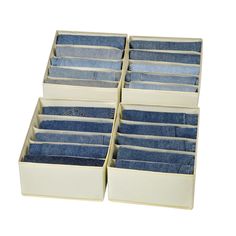 four pairs of blue jeans are stacked in a white box on top of each other