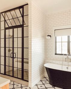 a black and white bathroom with a claw foot bathtub next to a shower stall