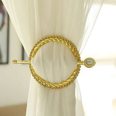 a close up of a curtain with a gold colored ring on it's side