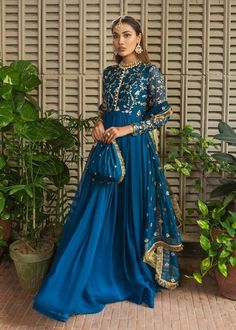 this Floor-Length Anarkali, a captivating wedding evening gown that seamlessly fuses traditional Indian aesthetics with modern elegance. Drenched in a mesmerizing shade of royal blue, this ensemble stands out as a statement piece, perfect for those seeking to make a memorable impression at weddings or any special evening affair. The Anarkali silhouette, extending gracefully to the floor, exudes regality and sophistication. Crafted with meticulous attention to detail, the gown features intricate embellishments and delicate embroidery, creating a harmonious play of textures and patterns. The opulent design showcases the timeless craftsmanship synonymous with Indian wedding suits, offering a perfect blend of tradition and contemporary style. For any kind of customization i.e. fabric/color/sty Floor Length Anarkali, Wedding Evening Gown, Evening Wear Dresses, Chiffon Pants, Potli Bag, Plus Size Gowns, Anarkali Gown, Fitted Sleeves, Blue Gown