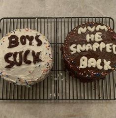 two decorated cakes sitting on top of a cooling rack with words written on the frosting