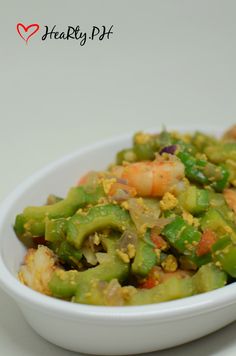 a white bowl filled with vegetables on top of a table