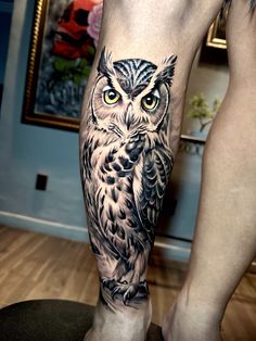 an owl tattoo on the leg of a man