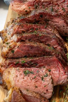 steak sliced up on a cutting board with herbs