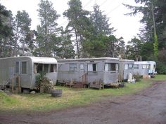 an rv park with three trailers parked in the grass