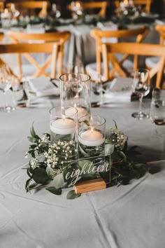 a table with candles and greenery on it