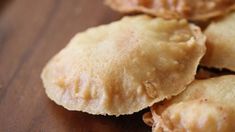 some dumplings are sitting on a wooden cutting board and ready to be cut into small pieces