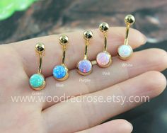 four different types of opalite piercings in gold plated brass, set on a person's hand