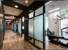 an office hallway with glass doors and hard wood flooring is pictured in this composite image