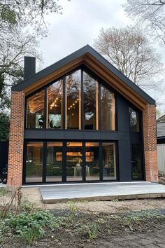 a modern house with large glass windows and wooden steps leading up to the front door