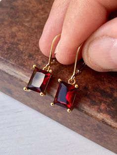 Garnet Earrings, January Birthstone, Dark Read Emerald Cut Earrings in Gold or Silver, Rectangular Baguette Drops, Garnet Jewelry for Women These elegant baguette earrings feature dark red rectangle gemstones prong set in your choice of gold filled or sterling silver. The vivid garnet emerald cut drops are suspended from lever back ear wires in the finish of your choice. These are great choice for simple yet elegant earrings to wear virtually anywhere. Ideal gift for a woman born in January, as Luxury Rectangular Garnet Jewelry, Classic Rectangular Stone Earrings For Gift, Classic Earrings With Rectangular Stone For Gift, Classic Rectangular Stone Earrings As Gift, Formal Earrings With Lever Back And Rectangular Shape, Red Faceted Earrings For Anniversary, Red Rectangular Jewelry For Evening, Rectangular Red Jewelry For Evening, Red Faceted Earrings For Formal Occasions