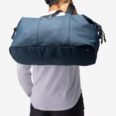 a man carrying a large blue duffel bag