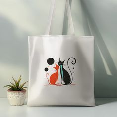 Add a touch of romance to your daily routine with our "Romantic Cat Couple Satin Tote Bag." This artistic and stylish tote bag features a striking design of two elegant cats in love, accentuated with bold colors and modern lines. The unique artwork adds a sense of charm and sophistication to any outfit, making it perfect for everyday use. * Material: 100% polyester, luxury satin white, making it strong and durable for everyday use. * Size: Measures 38cm W x 40cm H, 75cm H with handle, offering a White Bag With Cat Design As A Gift, White Bag With Cat Design For Gift, White Bags With Cat Design For Gift, White Cat Design Bag As A Gift, White Cat Design Bag As Gift, White Shoulder Bag With Cat Design As Gift, White Shoulder Bag With Cat Design For Gift, Cat Design Bags Perfect For Gifts, Trendy Cat Design Shoulder Bag Gift