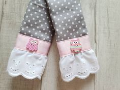 two pairs of gloves with owls and polka dots on them, sitting on a wooden surface