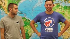 two men standing next to each other in front of a map