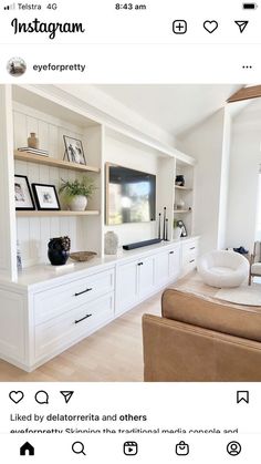 an image of a living room with white furniture and shelves on the wall, including a flat screen tv