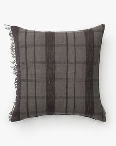 a gray and black plaid pillow with fringes