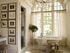 a bathroom with a claw foot tub and chandelier hanging from it's ceiling