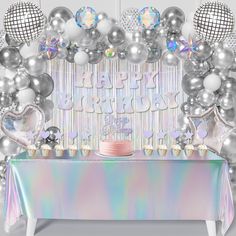 a table topped with a cake covered in frosting next to balloons and disco balls