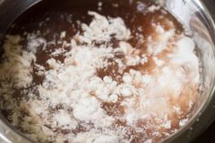 the food is being cooked in the pot on the stove burners are covered with white stuff