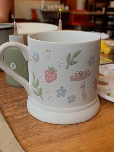 a white coffee cup sitting on top of a wooden table