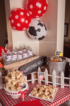 a table topped with lots of food and balloons