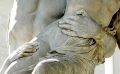 a close up of a statue with one hand on the other's back,