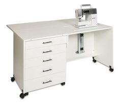 a sewing machine sitting on top of a white desk next to a drawer with drawers