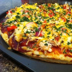 a pizza sitting on top of a pan covered in cheese and veggie toppings