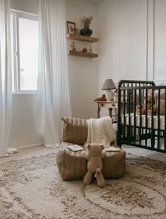 a baby's room with a crib, rocking chair and teddy bear on the floor