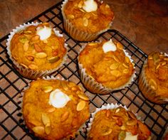 several muffins on a cooling rack with white frosting and almonds in them