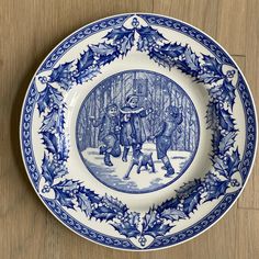 a blue and white plate sitting on top of a wooden table next to a wall