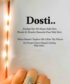 someone is holding up a book with the words dosti written on it in front of them