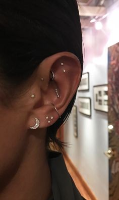 a close up of a person with ear piercings on their ears and behind the ear