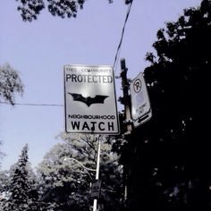 a street sign that is on the side of a pole with trees in the background