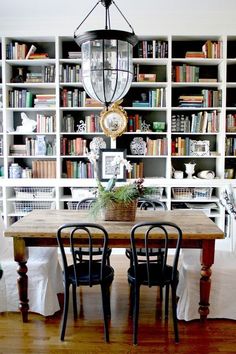 the dining room table is surrounded by bookshelves