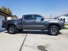 a gray truck parked in front of a garage