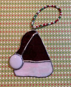 a glass ornament with a beaded necklace attached to it on a table