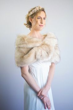 a woman wearing a white dress and fur stole