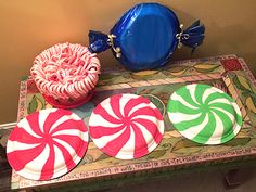 candy canes and lollipops are sitting on a tray next to a blue bowl